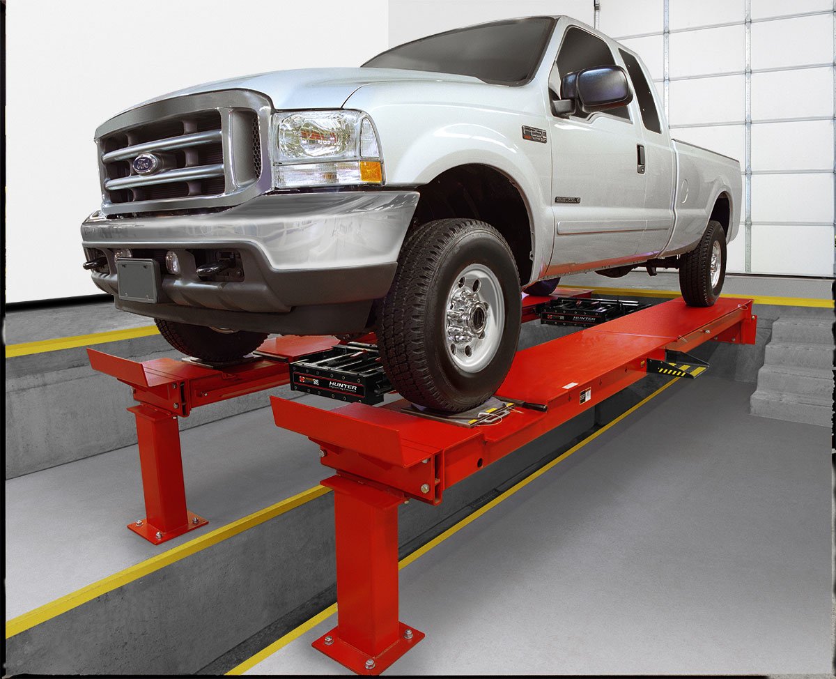 white truck on pit rack in shop