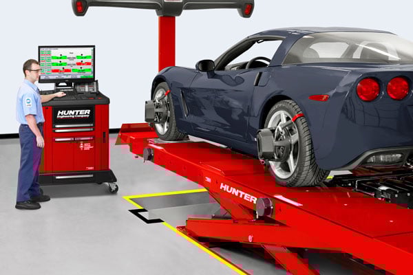 blue car getting wheel alignment on flush mount lift