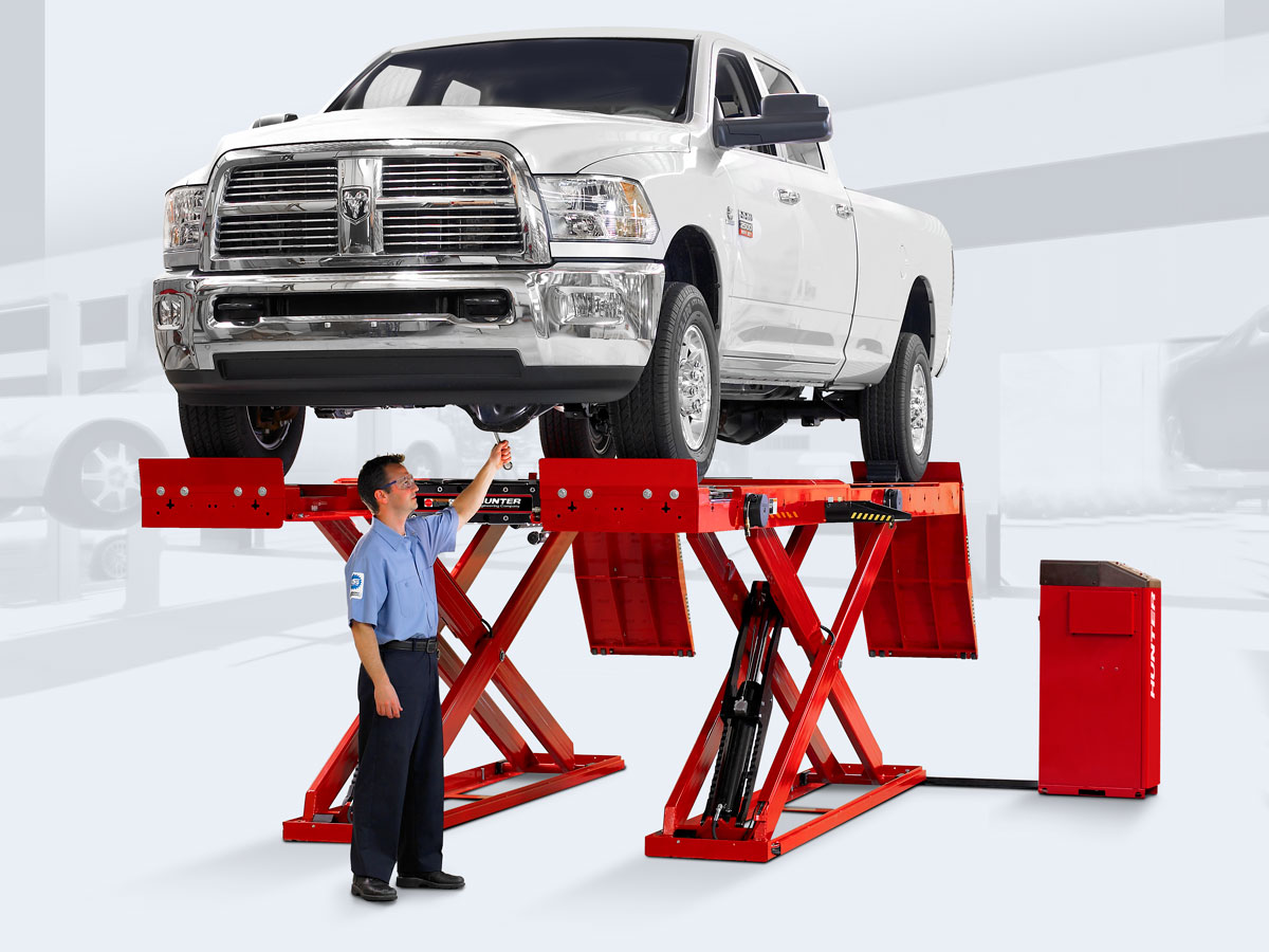 technician servicing truck on alignment rack
