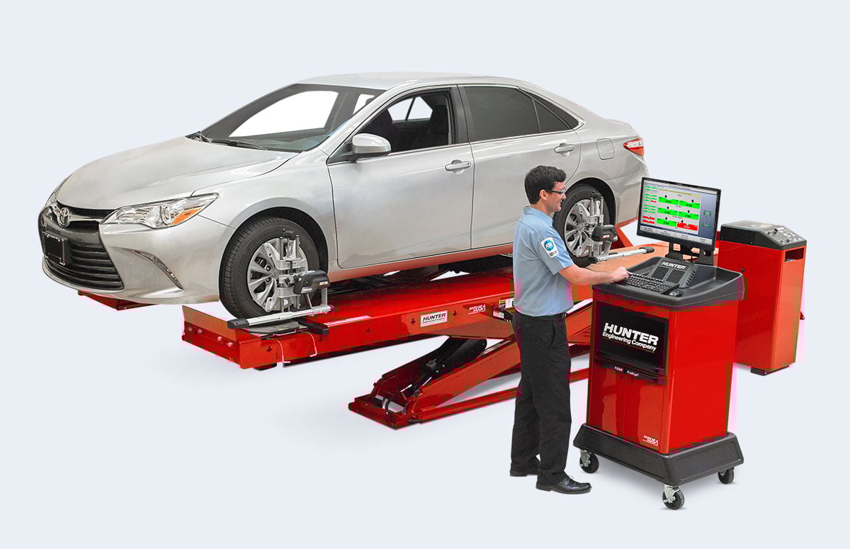 technician looking at alignment measurements on alignment machine monitor