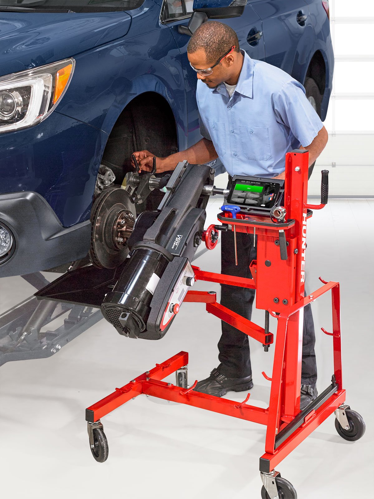 tech using hunter autocomp elite brake lathe on blue vehicle