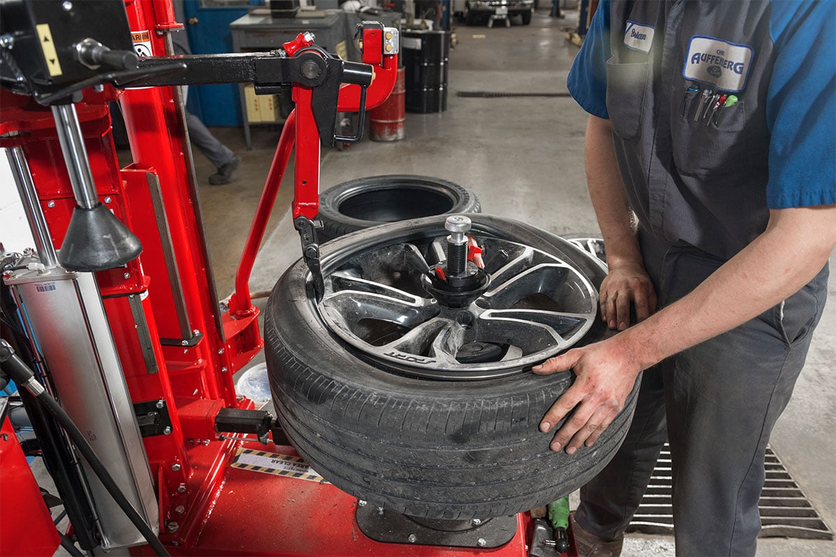 tc-tc39-realshop-auffenbergford4.jpg tech using leverless mount head on hunter tc39 tire changer