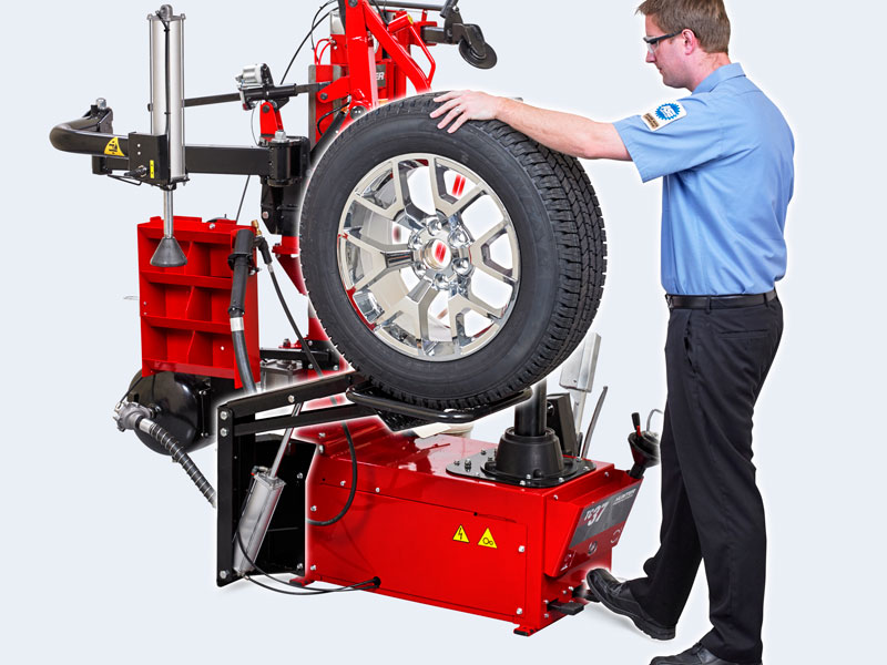 technician using wheel lift feature on center clamp tire changer
