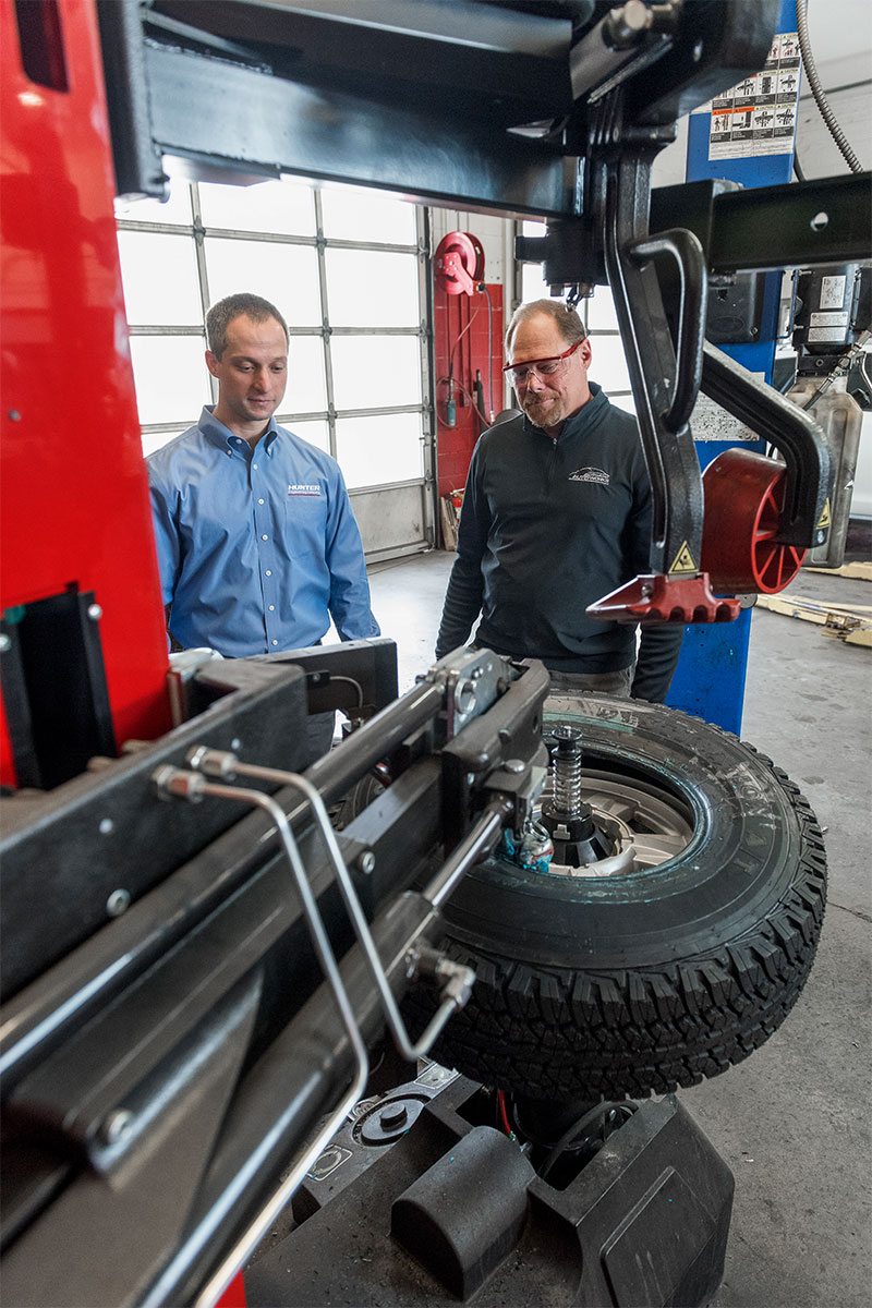 tc-tcr-realshop-bernhardautoworks07.jpg hunter representative and technician looking at revolution tire changer